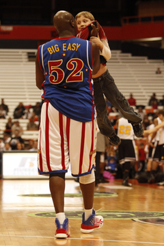 Big Easy grabs a fan volunteer by the collar after the fan misses a 3-pointer, hoisting him into the air.