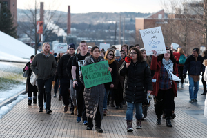 Arva Hassonjee (green sign) and Nedda Sarshar (megaphone) lead hundreds of students down Syracuse University's promenade on Thursday, Feb. 2, 2017 in a 