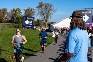 Family members and event employees urge runners on the final stretch of the Great NYS Marathon.