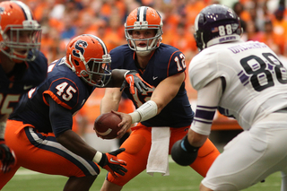 Quarterback Ryan Nassib (12) hands the ball to Jerome Smith (45).