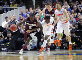 Will Cherry pushes the ball down the court as Jerami Grant chases.